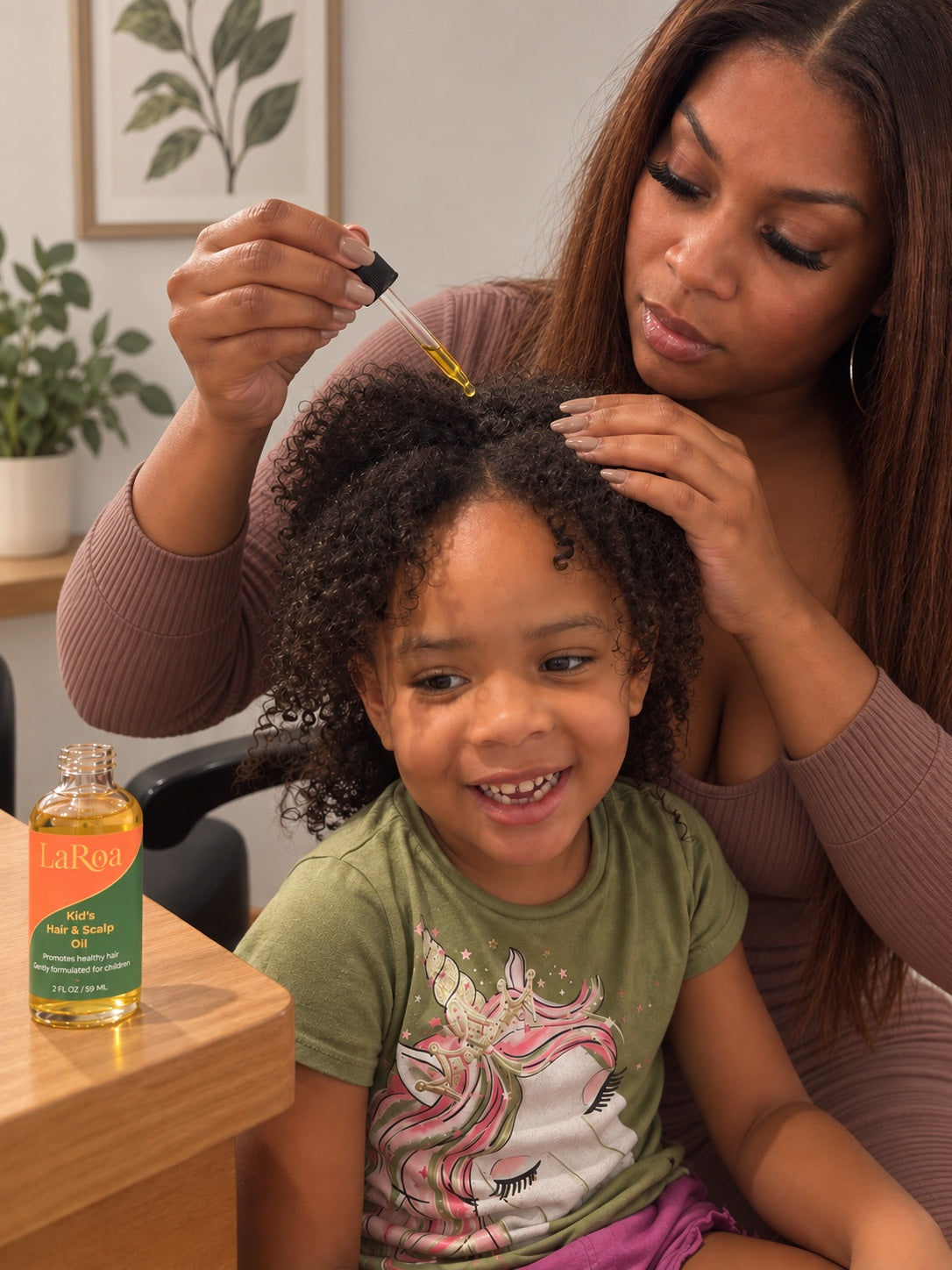 Mother applying LaRoa kids hair and scalp oil to curly hair