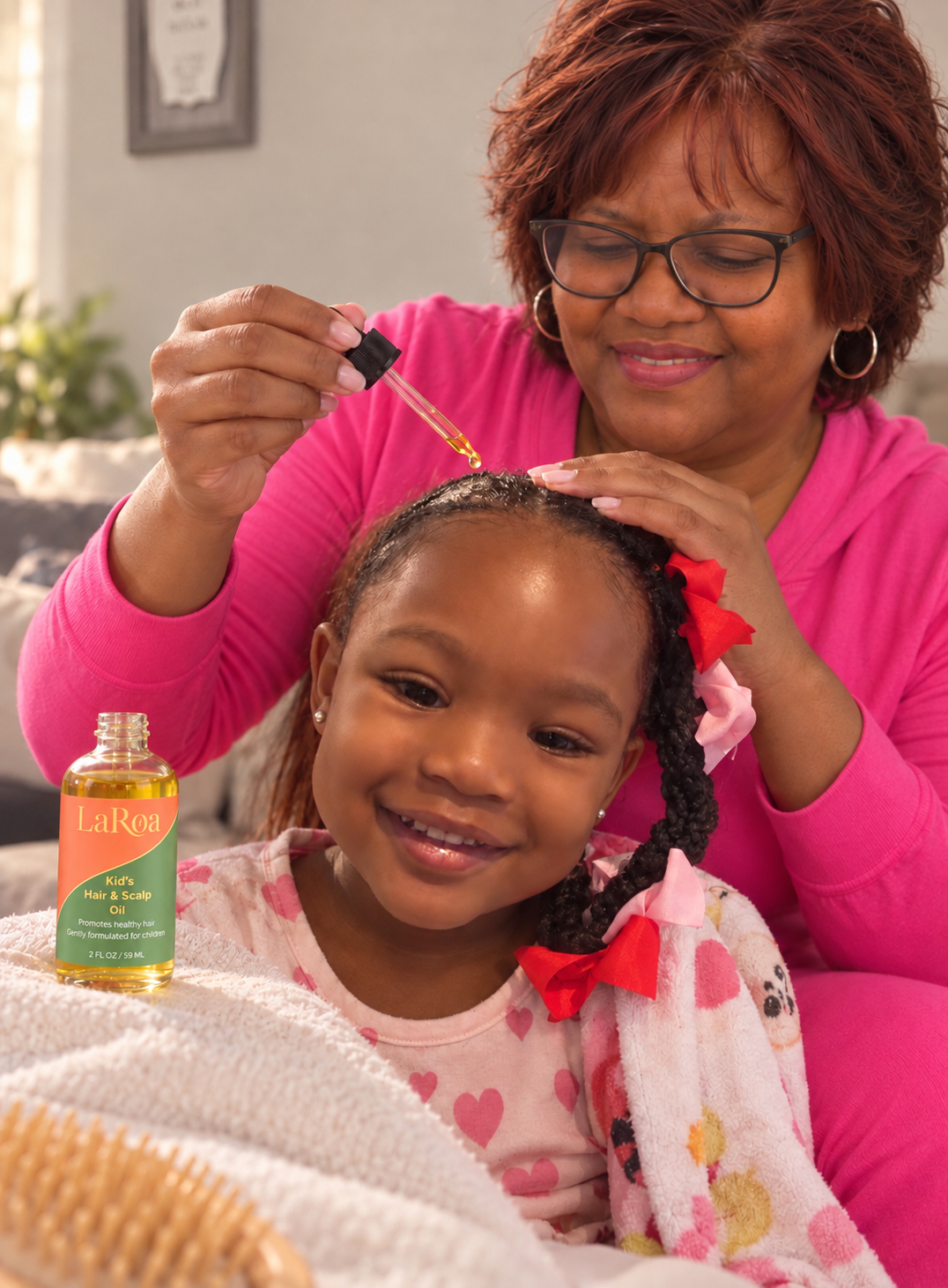 Older woman applying LaRoa kids hair and scalp oil to a little girl's braided hair